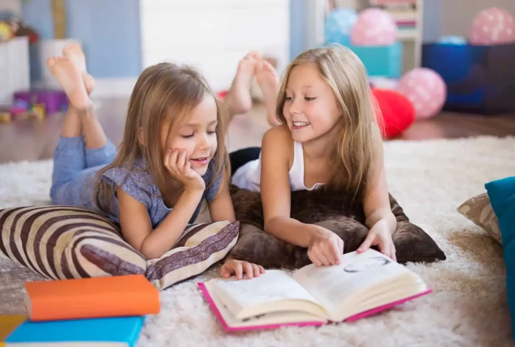 Two young girls reading a book together