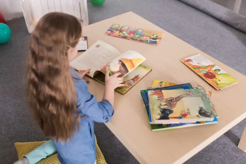 Child reading a picture book at a table